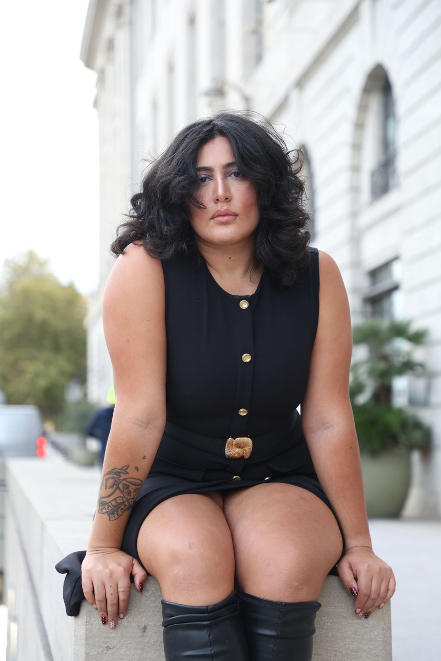 Jasmine assise sur un muret, tenue noire