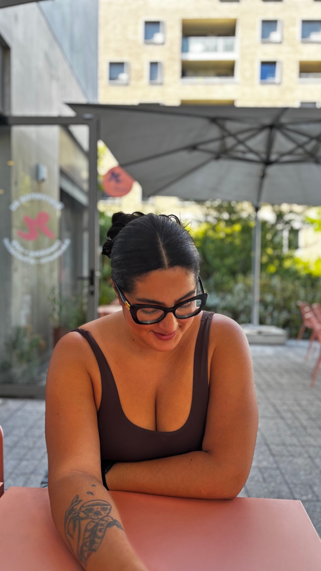 Jasmine sourit, regard baissé, en terrasse