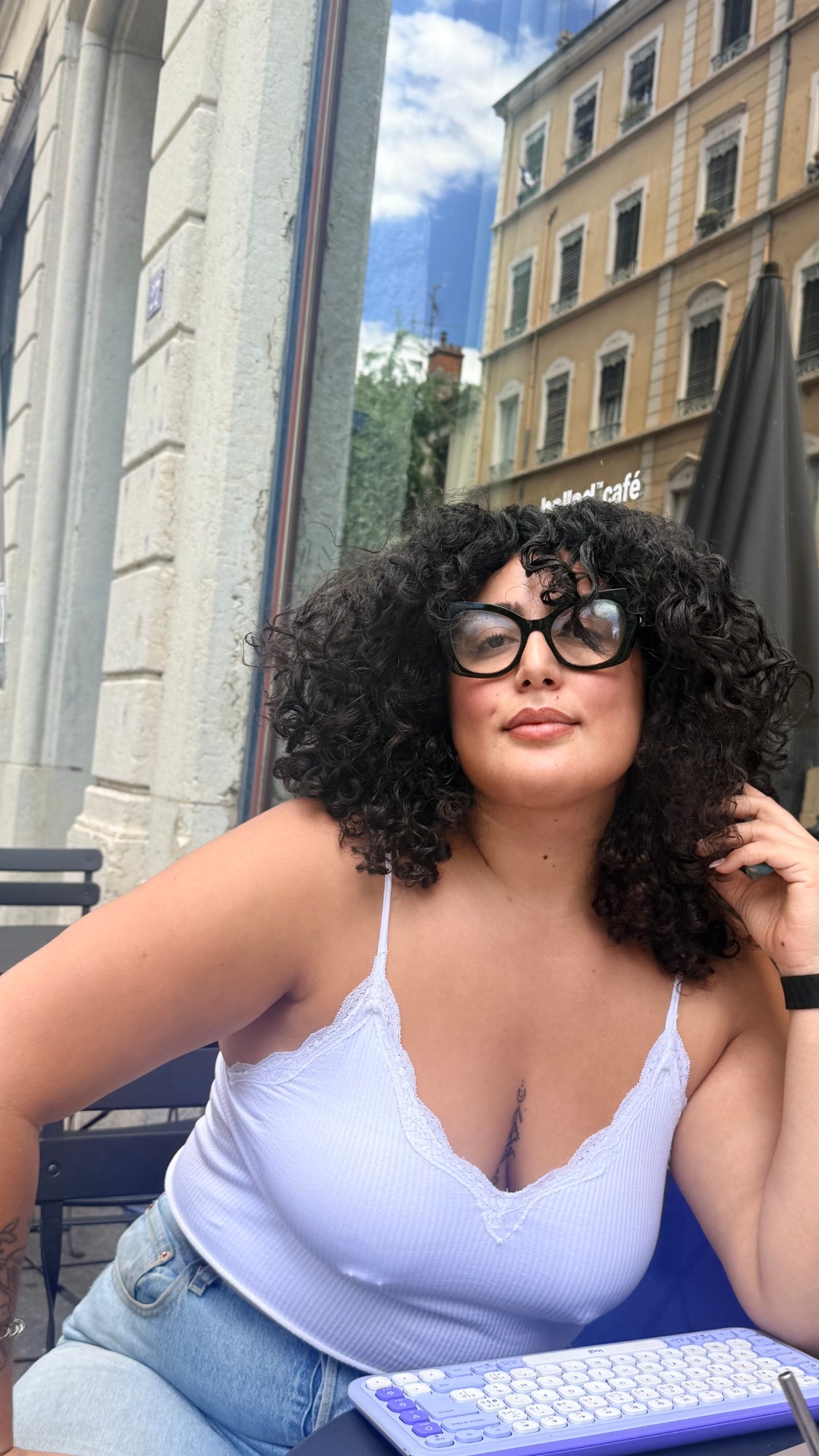 Jasmine au café, clavier sur la table, regard caméra